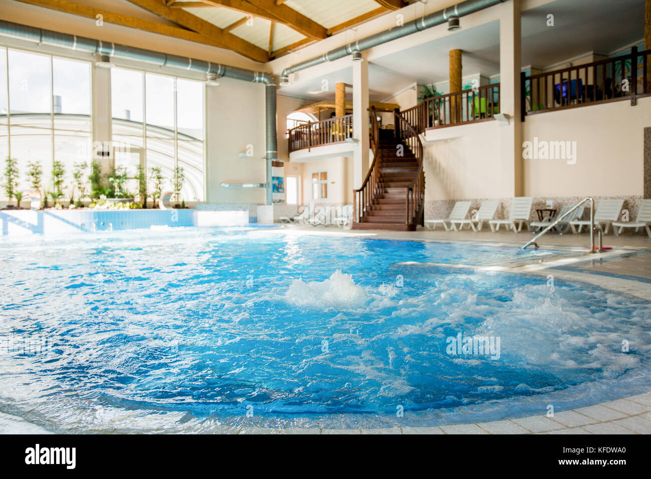 Interior of contemporary dayspa resort with whirlpool full of warm splashing water in the center Stock Photo