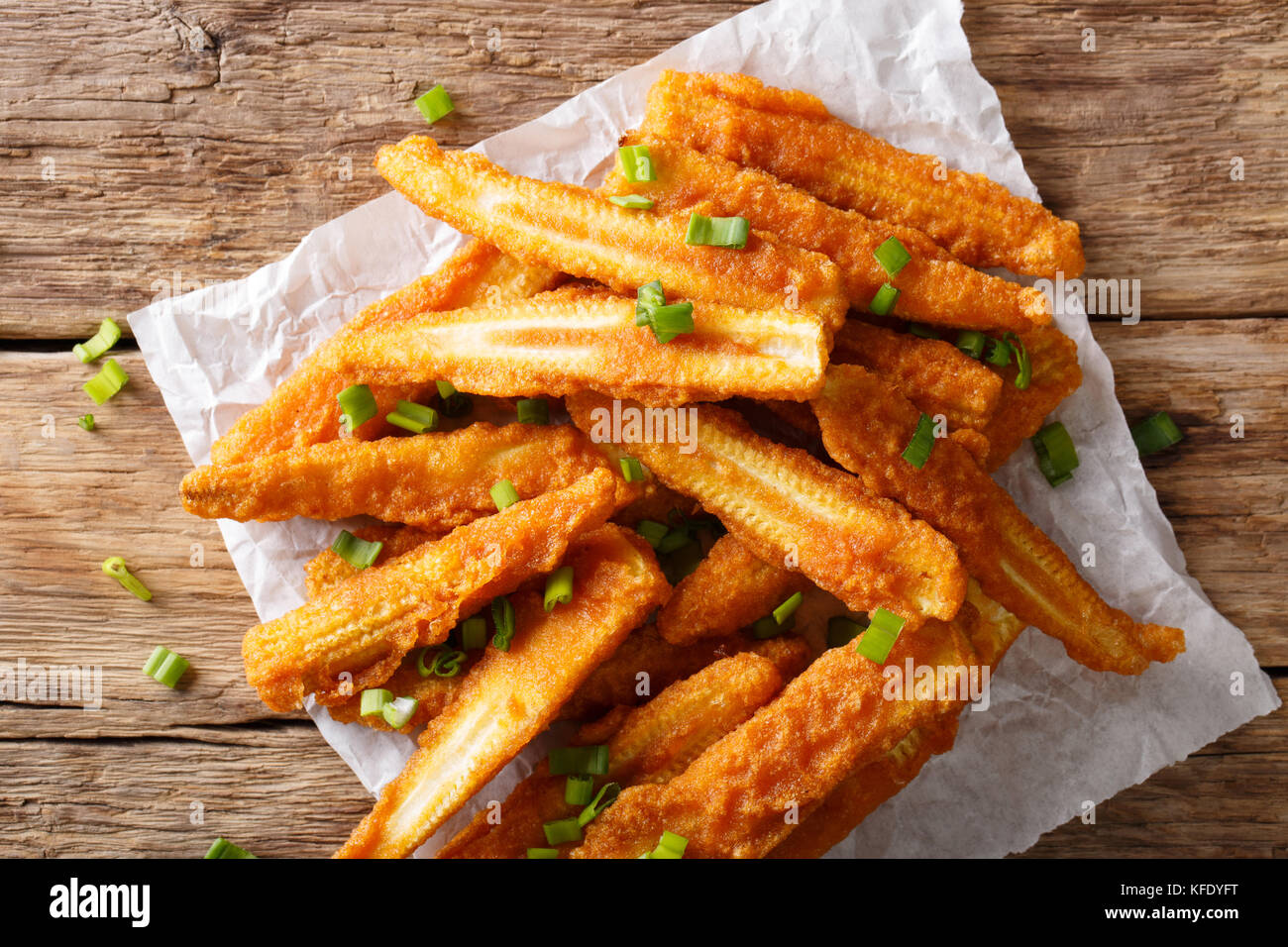 Fast food fried baby corn with green onions closeup on the table