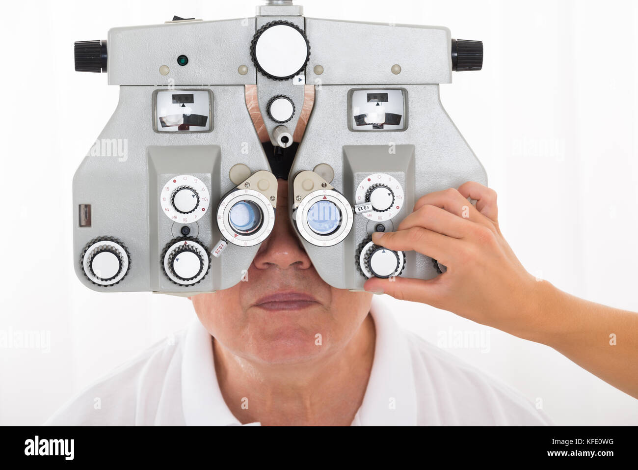 Close-up Of An Optometrist's Hand Adjusting Phoropter For Senior Male Patient Stock Photo