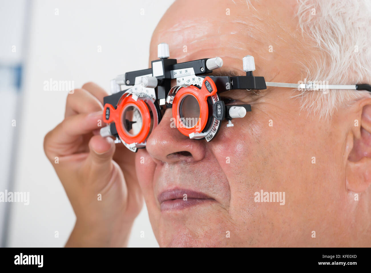 Close-up Of An Optometrist Checking Senior Male Patient Vision With Trial Frame At Eye Clinic Stock Photo