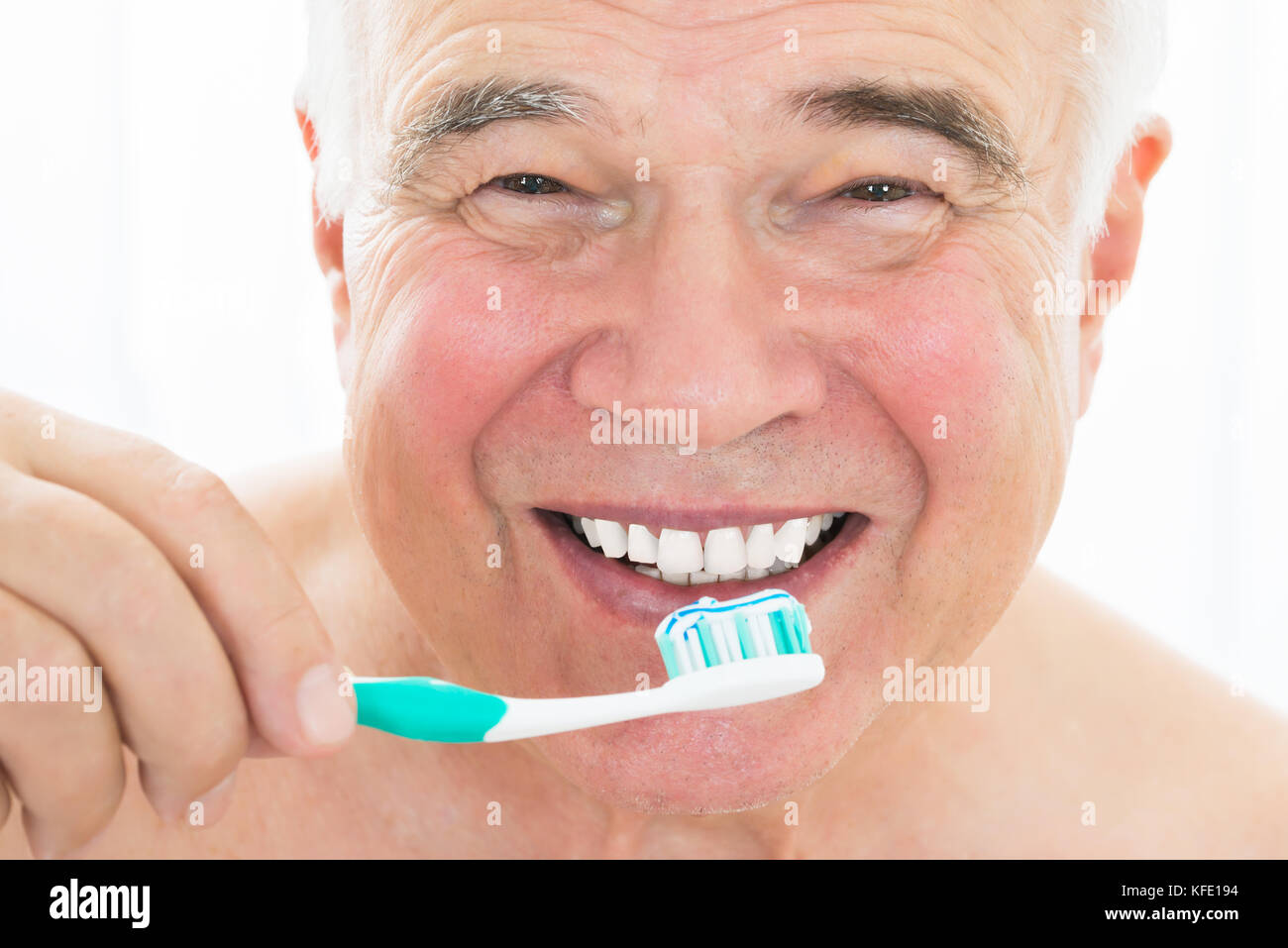 Close-up Of A Happy Senior Man Brushing His Teeth With Toothbrush Stock Photo