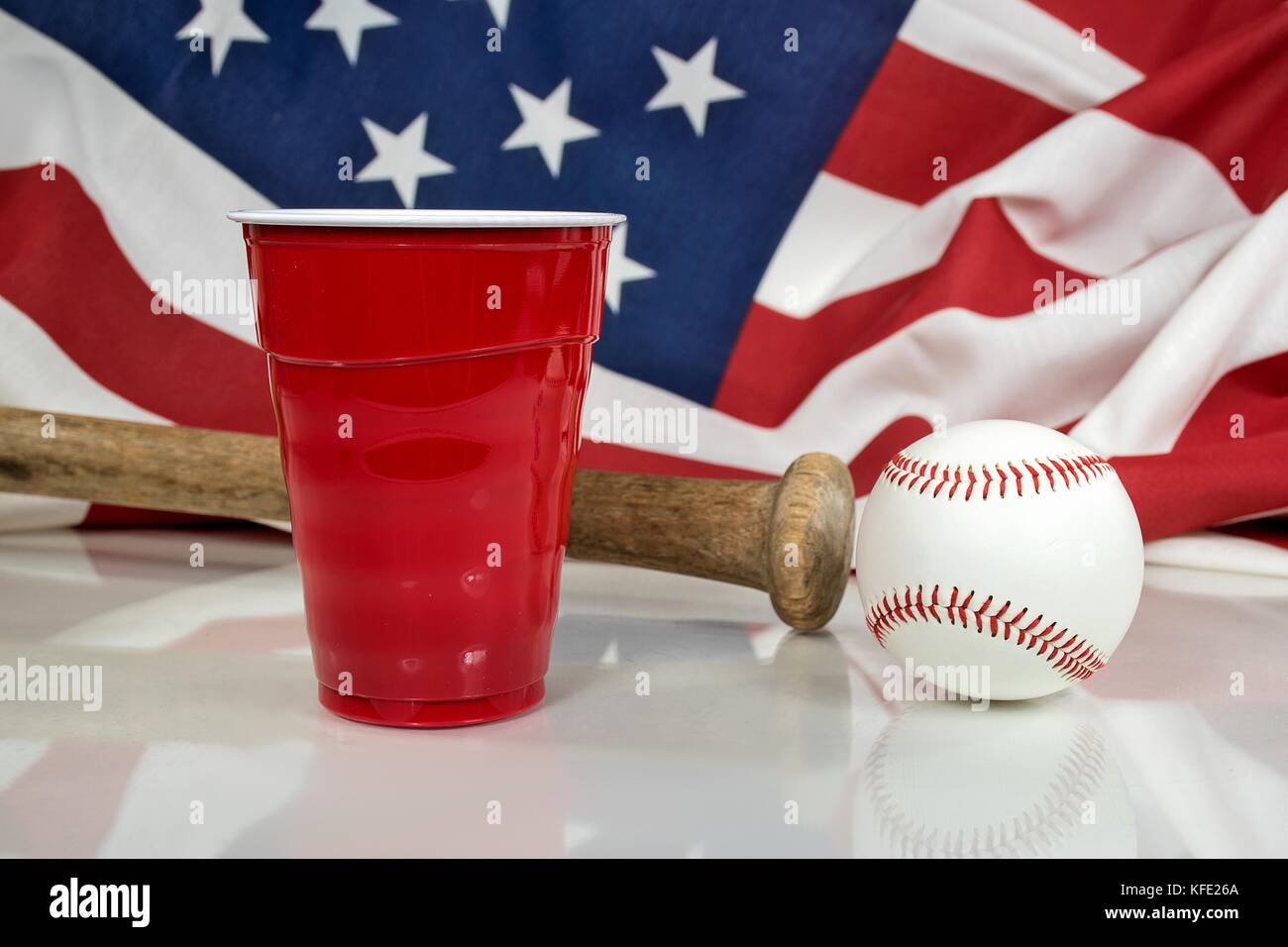 red party cup with wooden bat and baseball on shiny surface Stock Photo