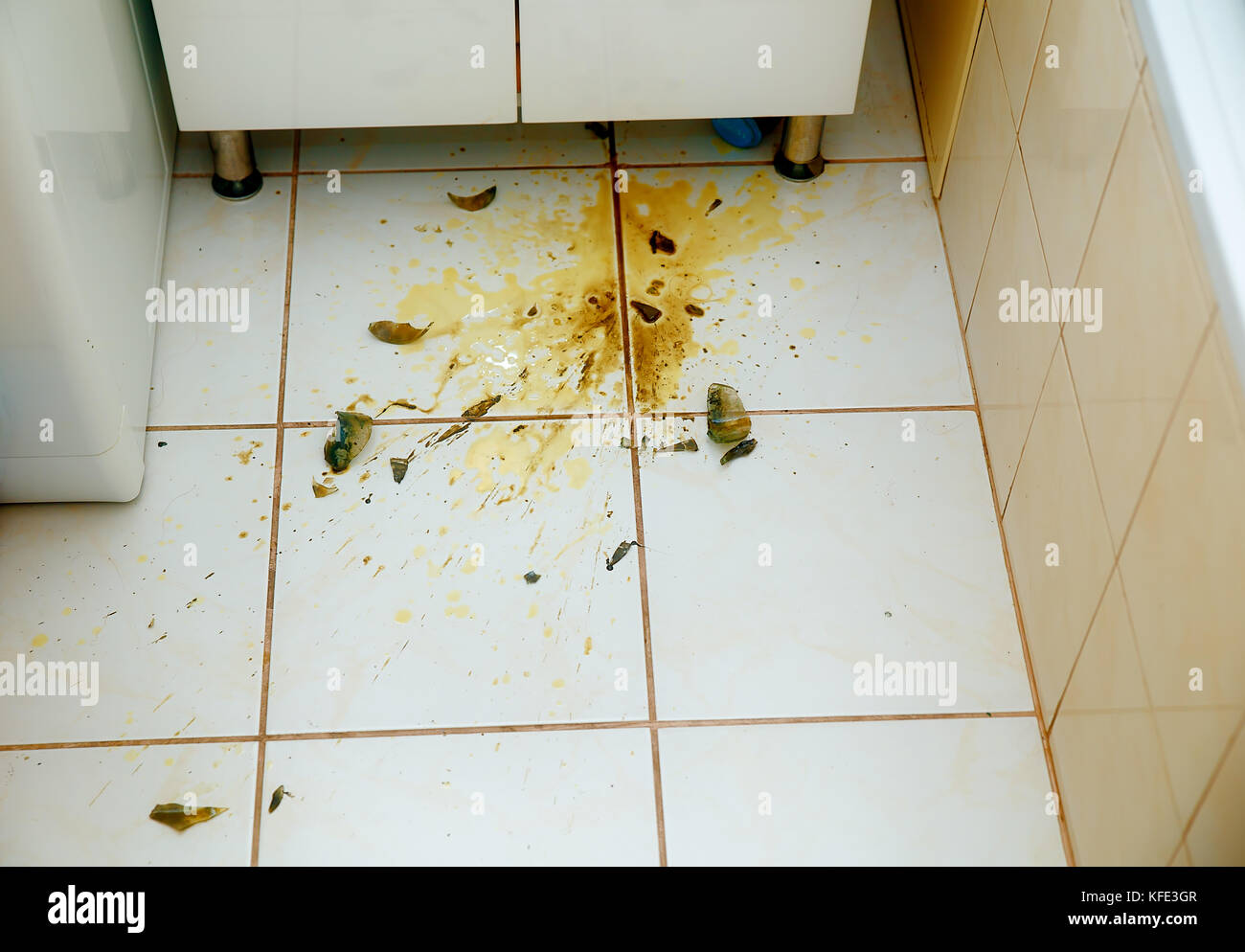 Colorful stains and broken glass on white bathroom tiles Stock Photo