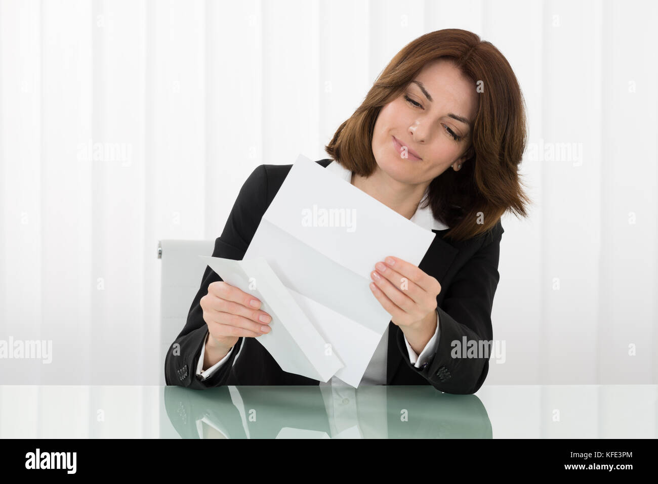 Young Businesswoman Holding Envelope With Letter In Office Stock Photo