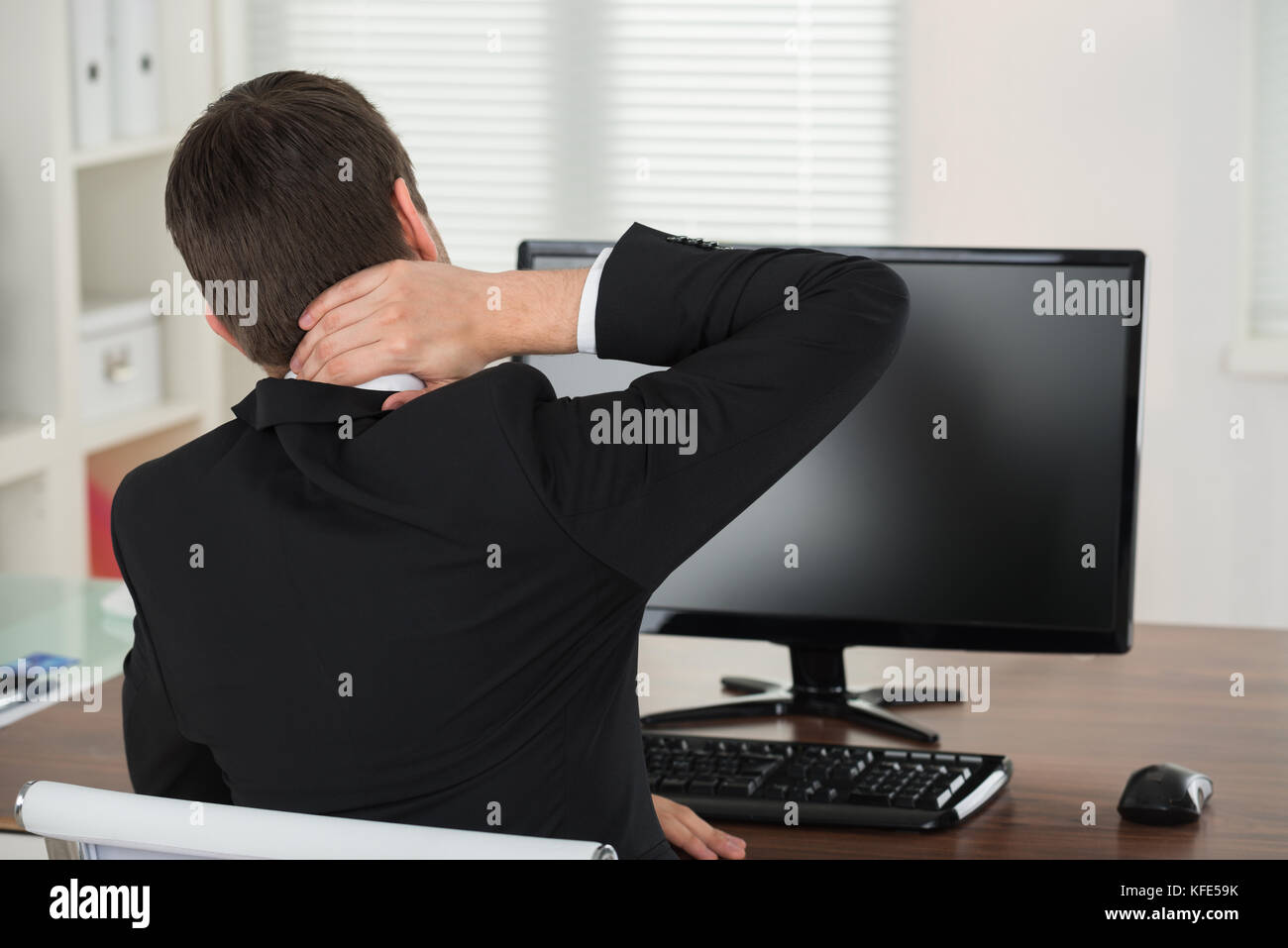 Businessman Suffering From Neck Pain While Working In Office Stock Photo Alamy