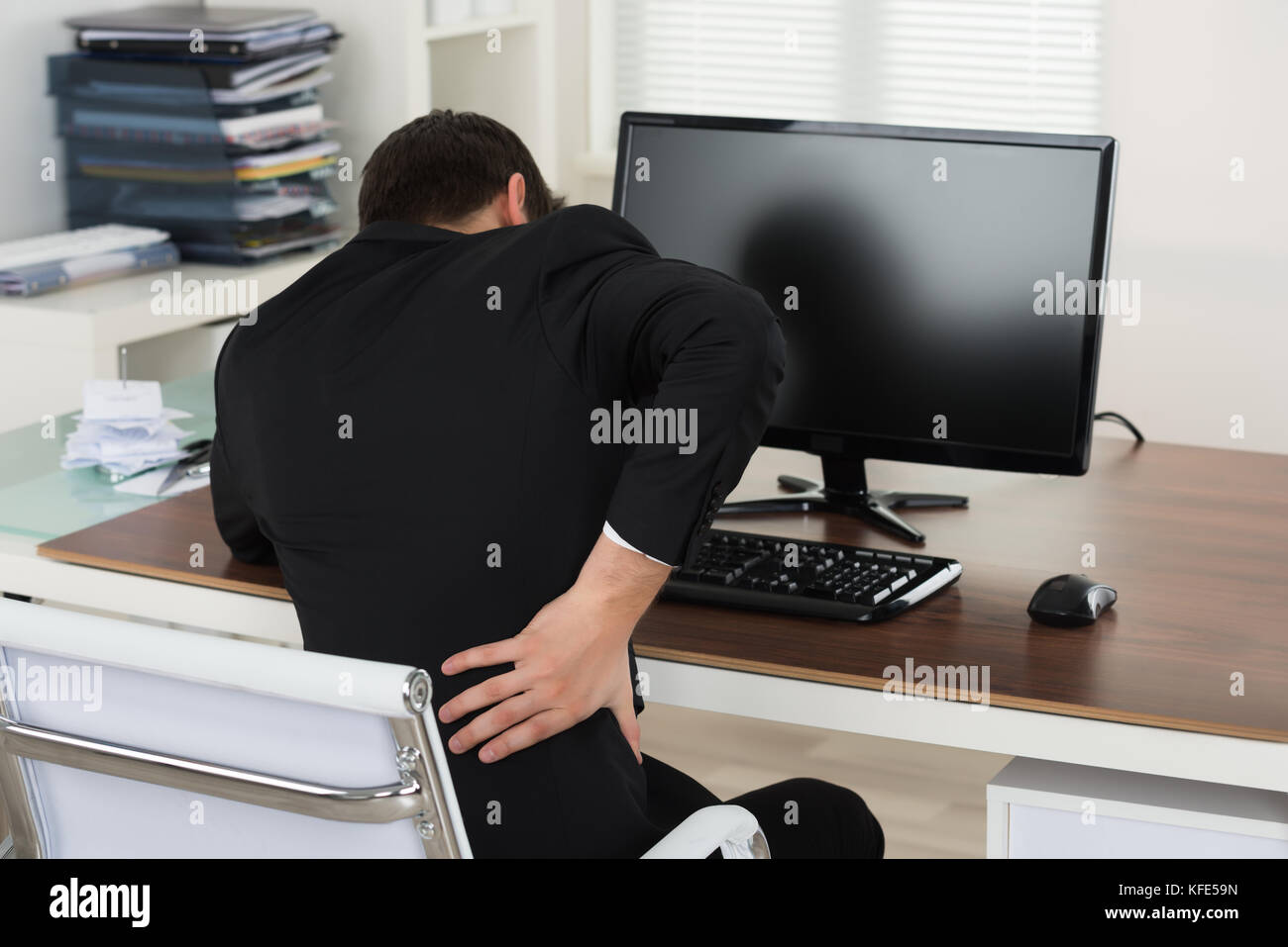 Businessman Suffering From Back Pain While Working In Office Stock ...