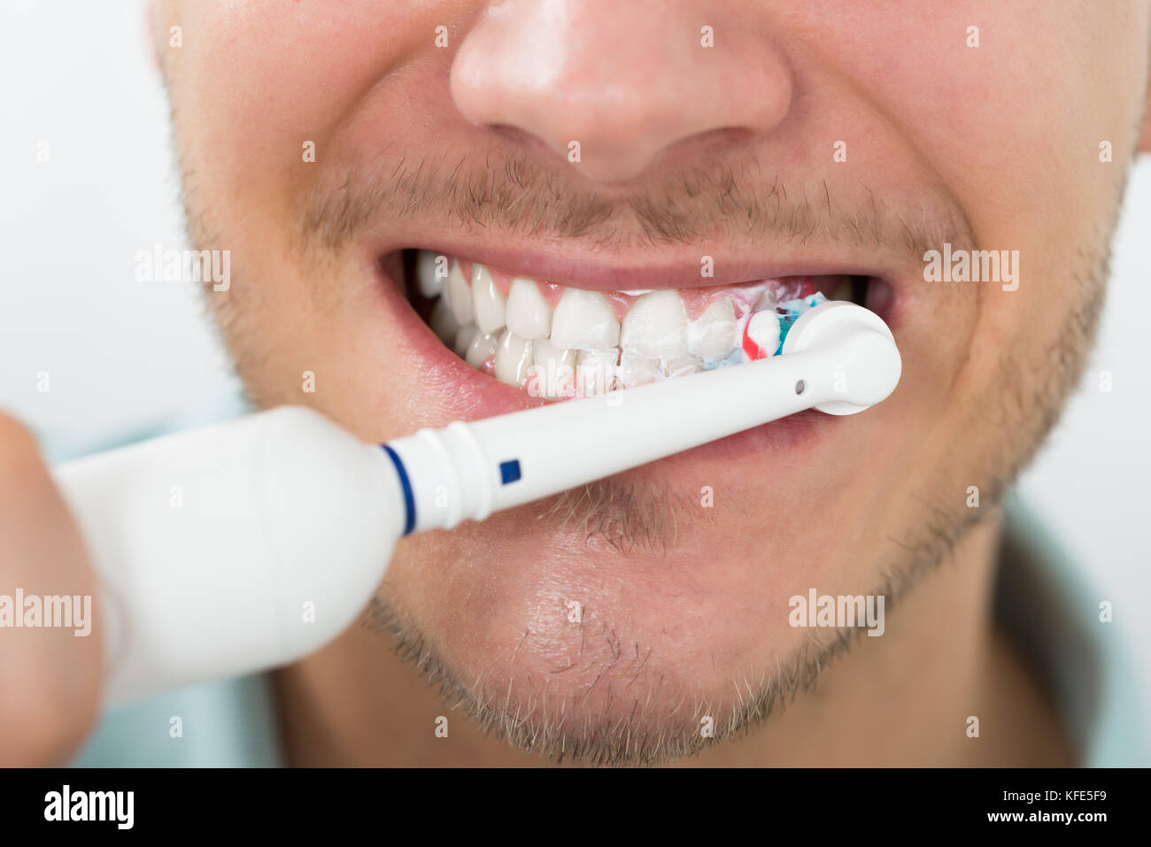Close-up Of Young Man Teeth With Electric Toothbrush Stock Photo