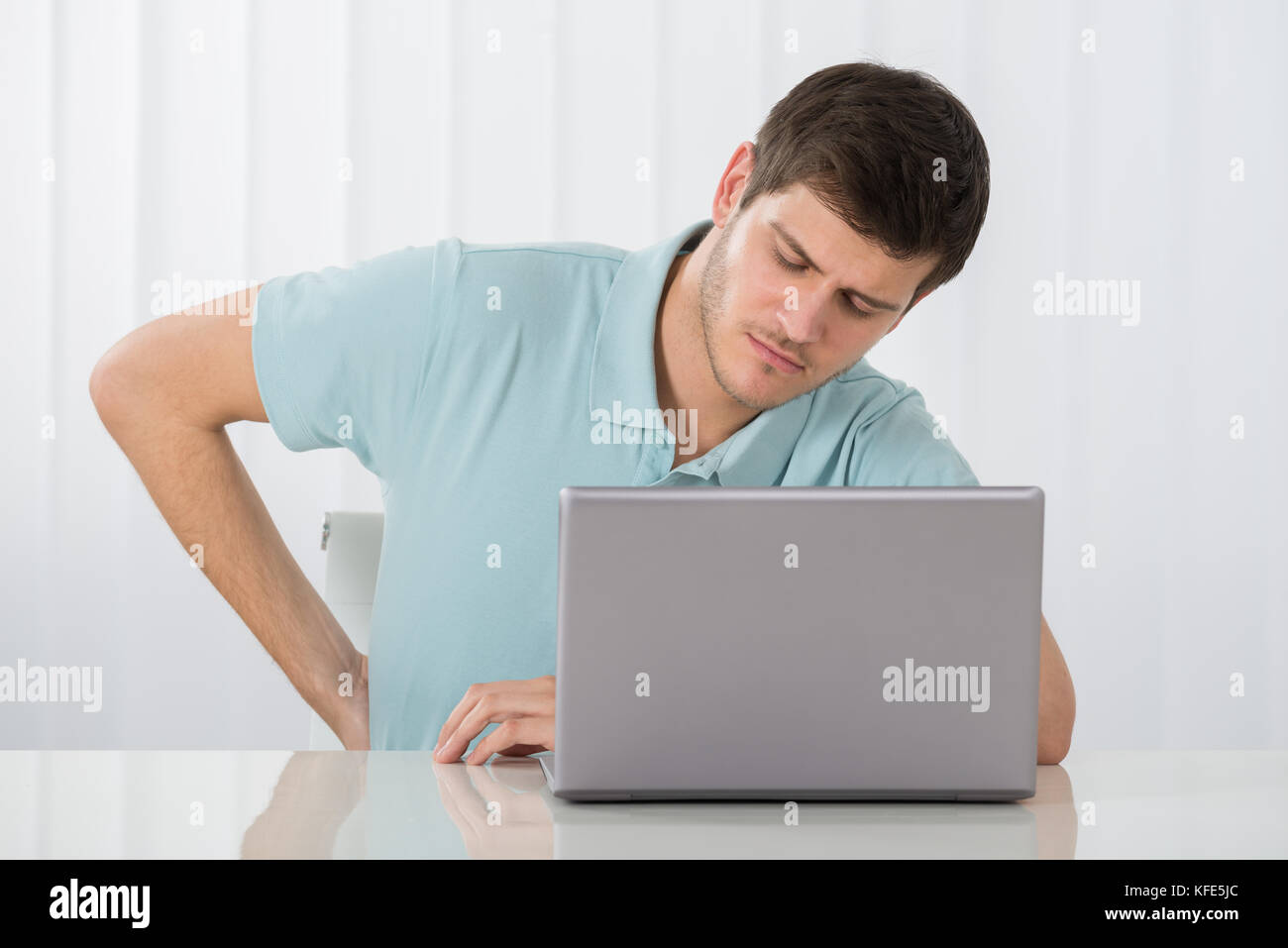 Young Man Suffering From Backache While Working On Laptop Stock Photo ...