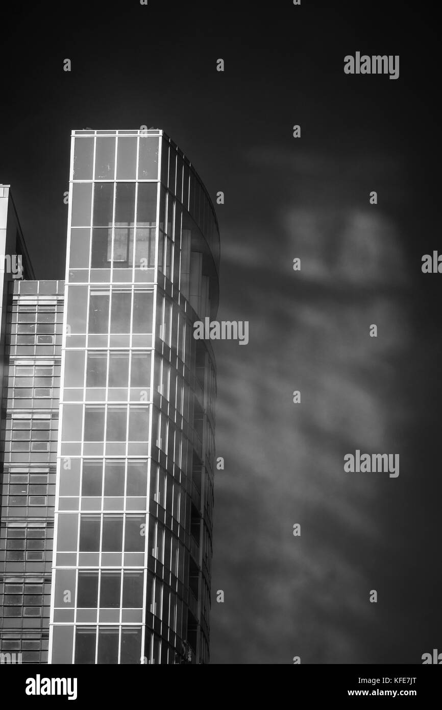 Light reflecting off a glass condo building creates ghosts in passing fog. Stock Photo