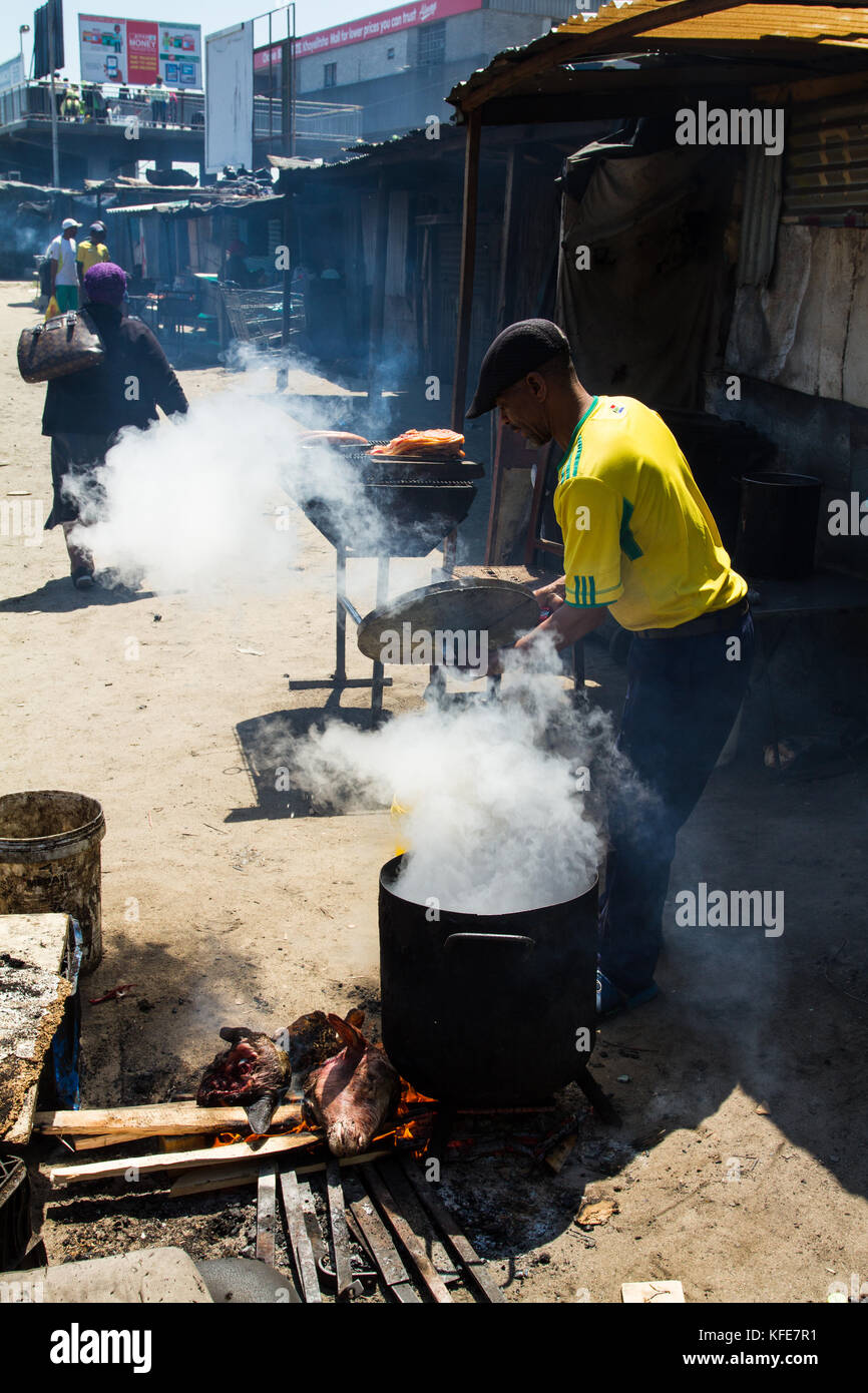 Street vendor cooking 'smiley' sheep head in Khayelitsha township, Cape Town, South Africa Stock Photo