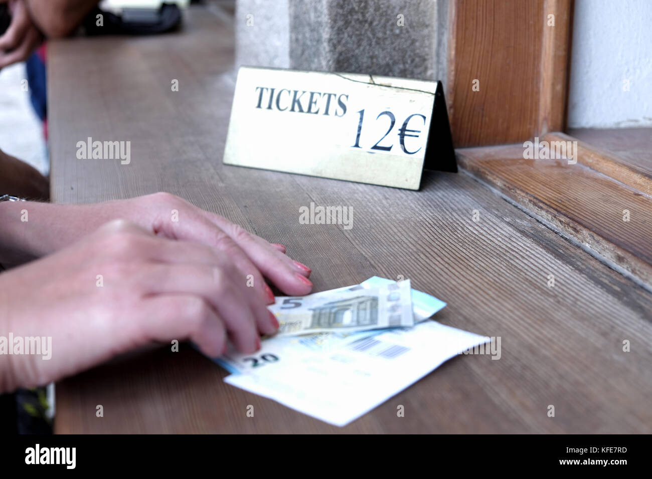 Someone paying the entrance fee for a ticket to an attraction in Euros with a twenty and five euro note. Acropolis at Lindos at Rhodes, Greece. Stock Photo