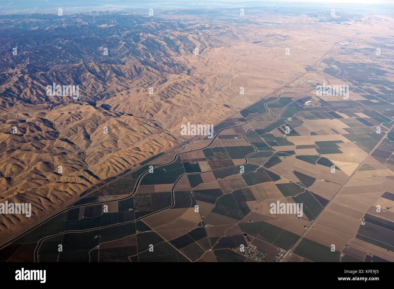 Contrasting aerial view of rugged mountain range between San Francisco and Sacramento and central valley farmland. Stock Photo