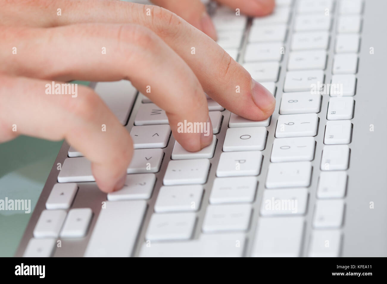 Closeup of man's hands typing on computer keyboard Stock Photo