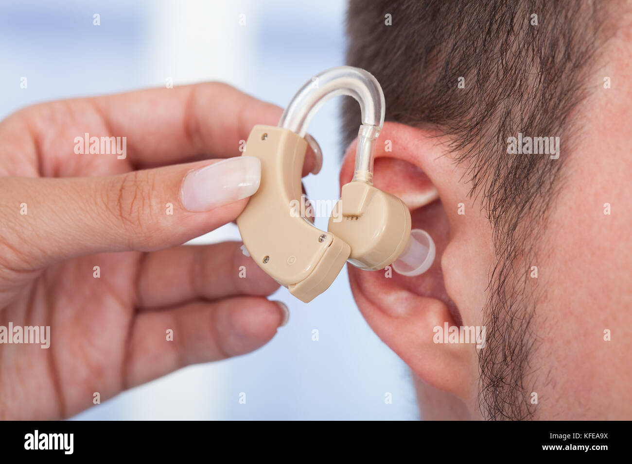Cropped image of doctor inserting hearing aid in man's ear Stock Photo ...