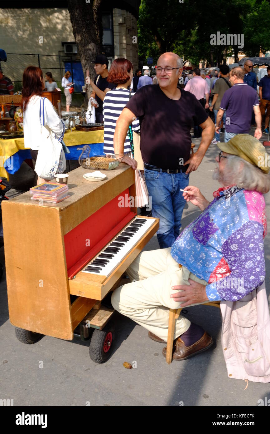 An old man plays piano a the the Marche au Puces, flea market at Portes de Vanves in Paris Stock Photo