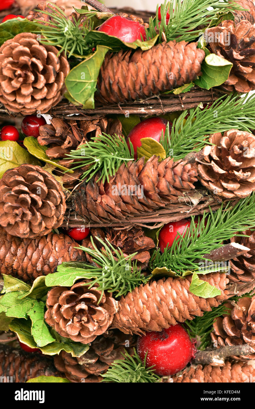 Fir cones, baubles and berries with holly and tinsel as christmas tree decorations for the festive season. Pine cones and fir cones with green and red Stock Photo