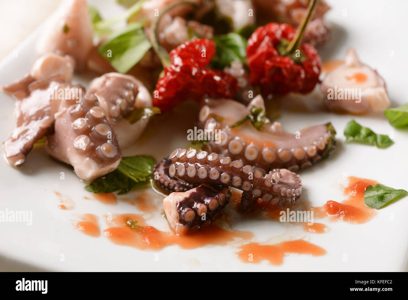Octopus with seasoning on white dish closeup Stock Photo Alamy