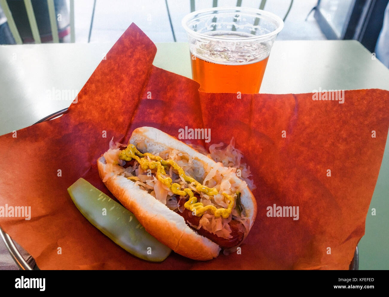 Hotdog with sauerkraut and mustard and a beer Stock Photo