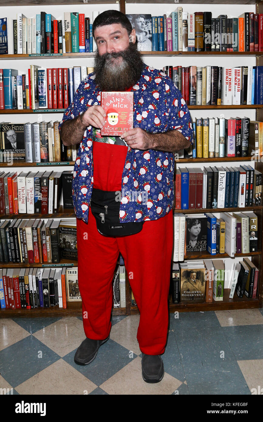 Mick Foley signs his book, 'Saint Mick: My Journey From Hardcore Legend to Santa's Jolly Elf' at Book Revue on October 19, 2017 in Huntington, NY. Stock Photo