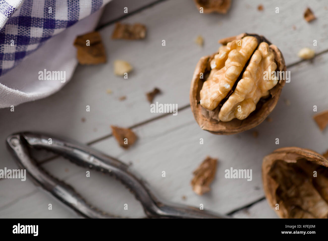 Cracked Walnut with Nutcracker on Wood Stock Photo