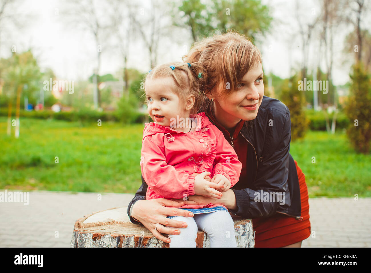 little girl sitting on a stump in the summer garden Stock Photo - Alamy