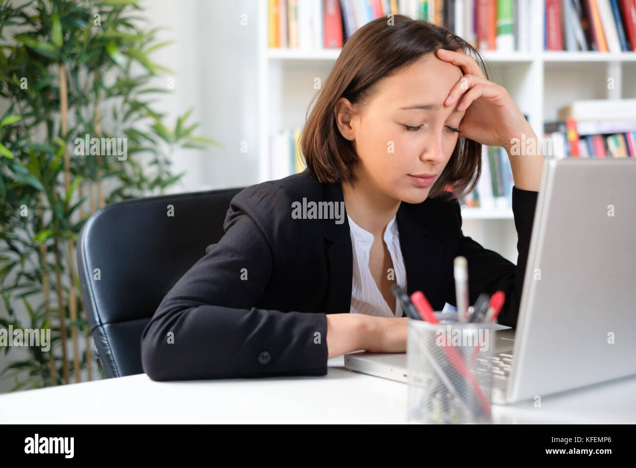 Overworked woman feeling exhausted because of too many job hours Stock