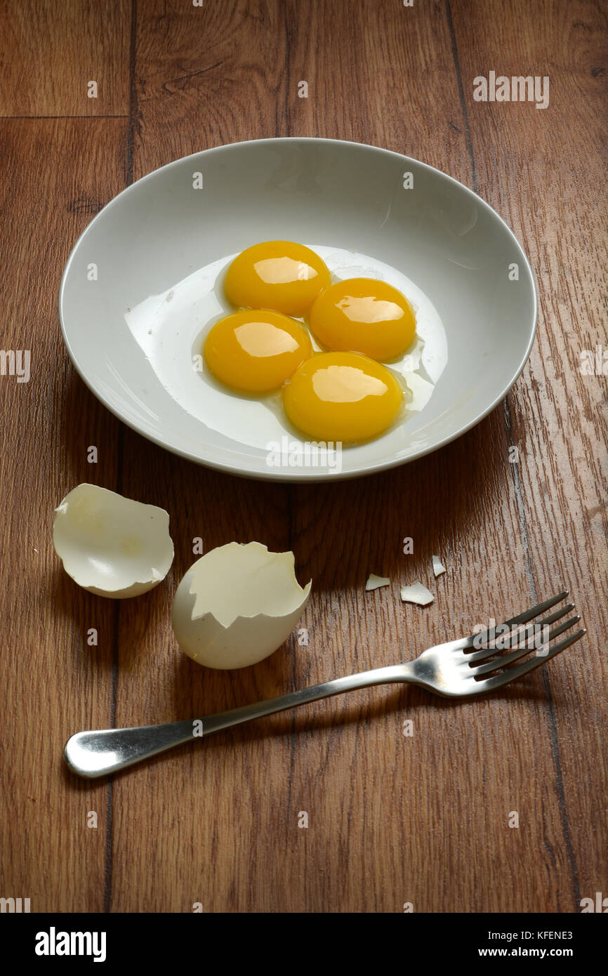 egg yolk with fork on wooden table - closeup Stock Photo