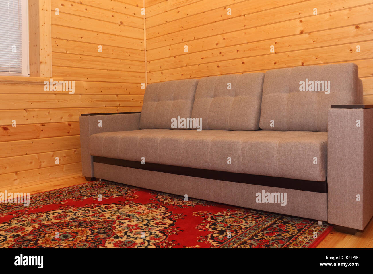 Wooden house interior - sofa and carpet photo Stock Photo