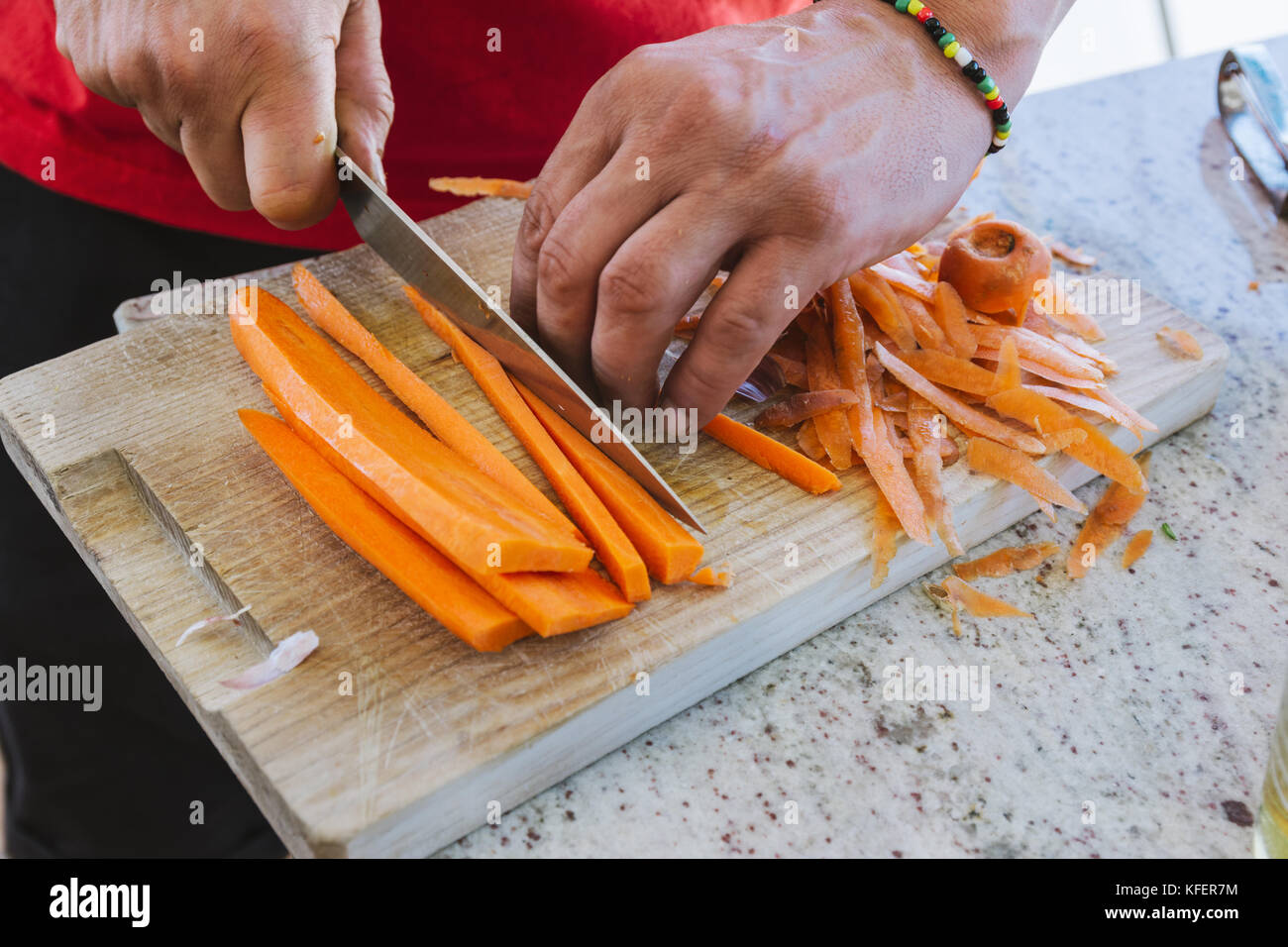 man cooking, cut carrot julienne style, in the kitchen Stock Photo