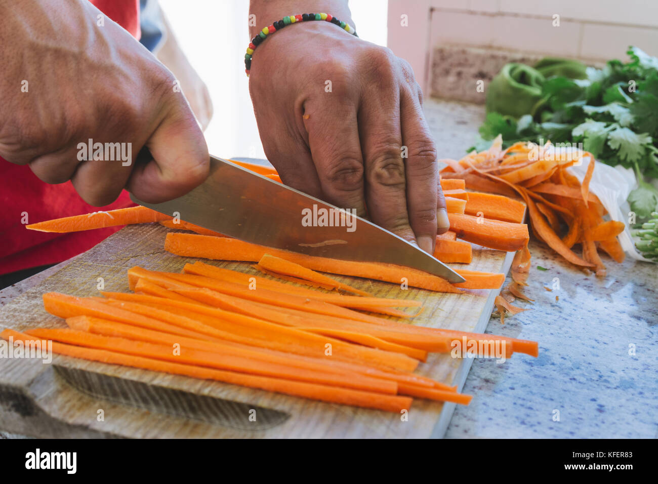man's hands, cut carrot julienne style, in the kitchen Stock Photo Alamy