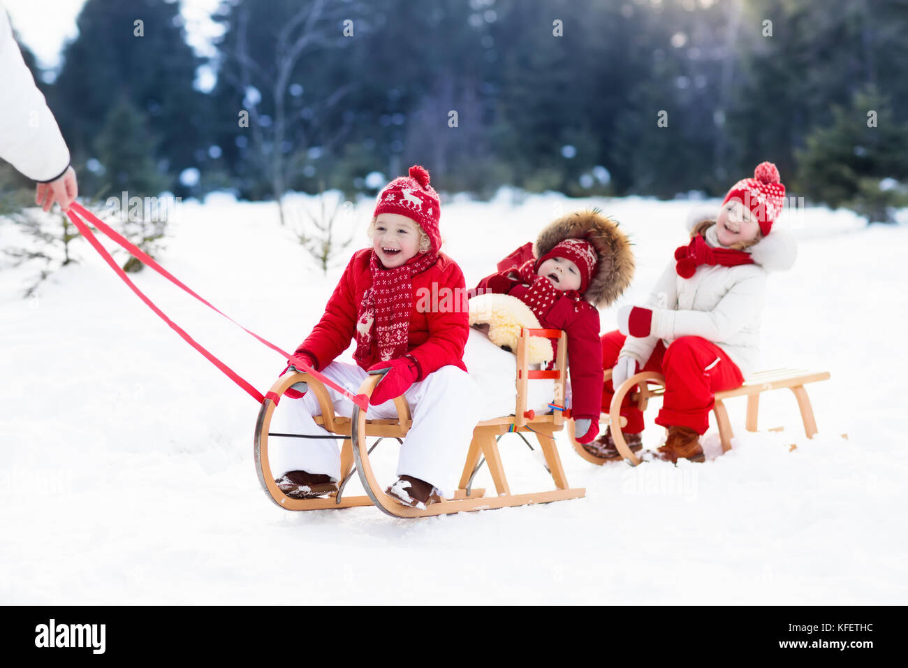 Infant Sleigh Riding Little girl and boy enjoy a sleigh ride. Child sledding. Toddler kid ...
