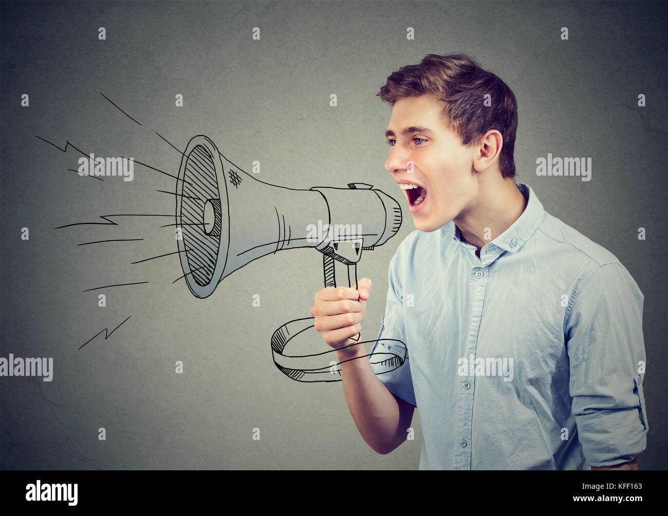 Young man screaming in a megaphone making announcement Stock Photo
