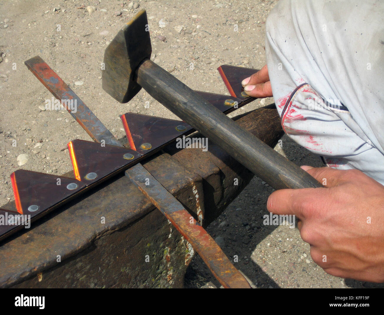 Somebody rivet harvester scythe teeth on anvil Stock Photo Alamy