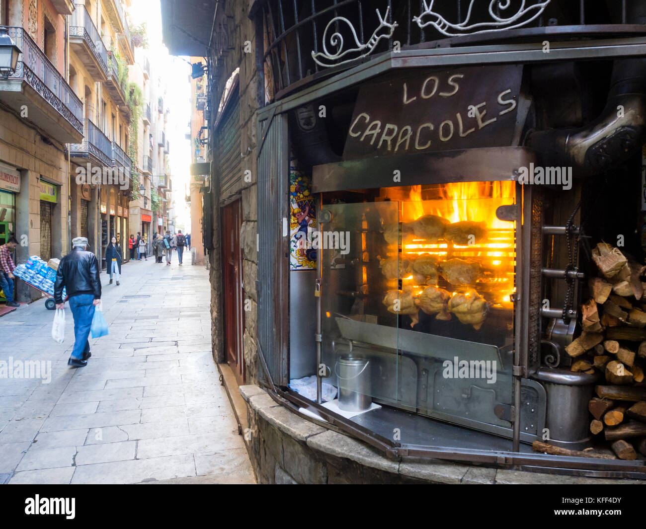 Barcelona, Spain - 11 Nov 2016: Chicken on a spit are rotating on the rotisserie grill of Barcelona's famous restaurant 'Los Caracoles'. Stock Photo