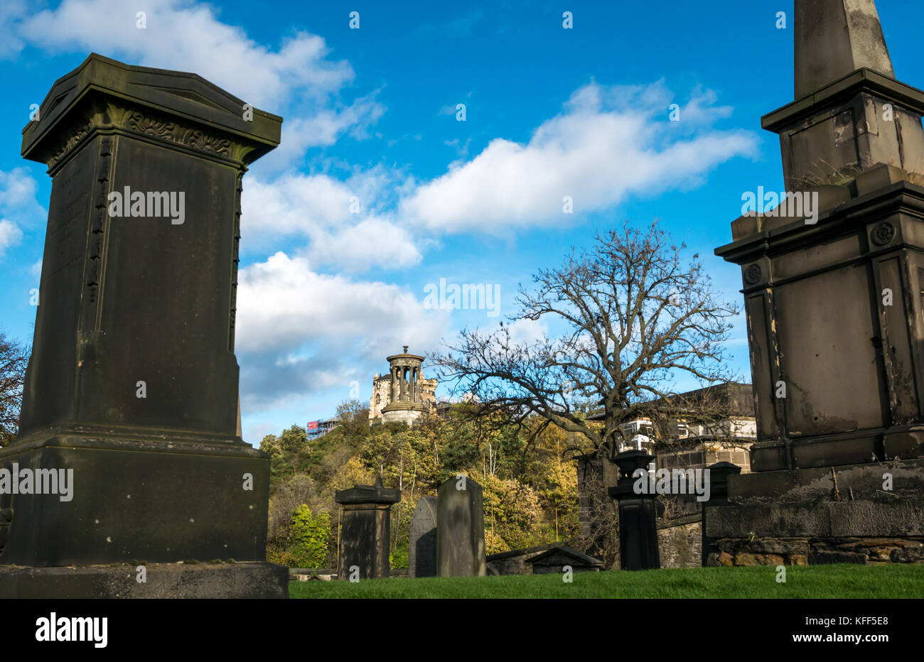 Gravestones in Old Calton burying ground cemetery, Edinburgh, Scotland and view to Calton Hill with the Dugald Stewart monument Stock Photo