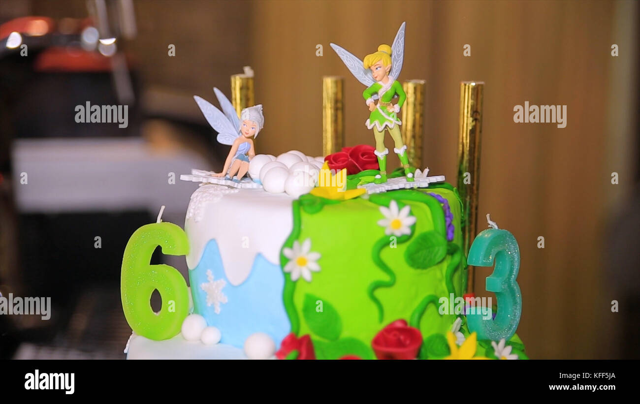 Green cake for birthday with fairies. Big celebration cake. Birthday cake with candles Stock Photo