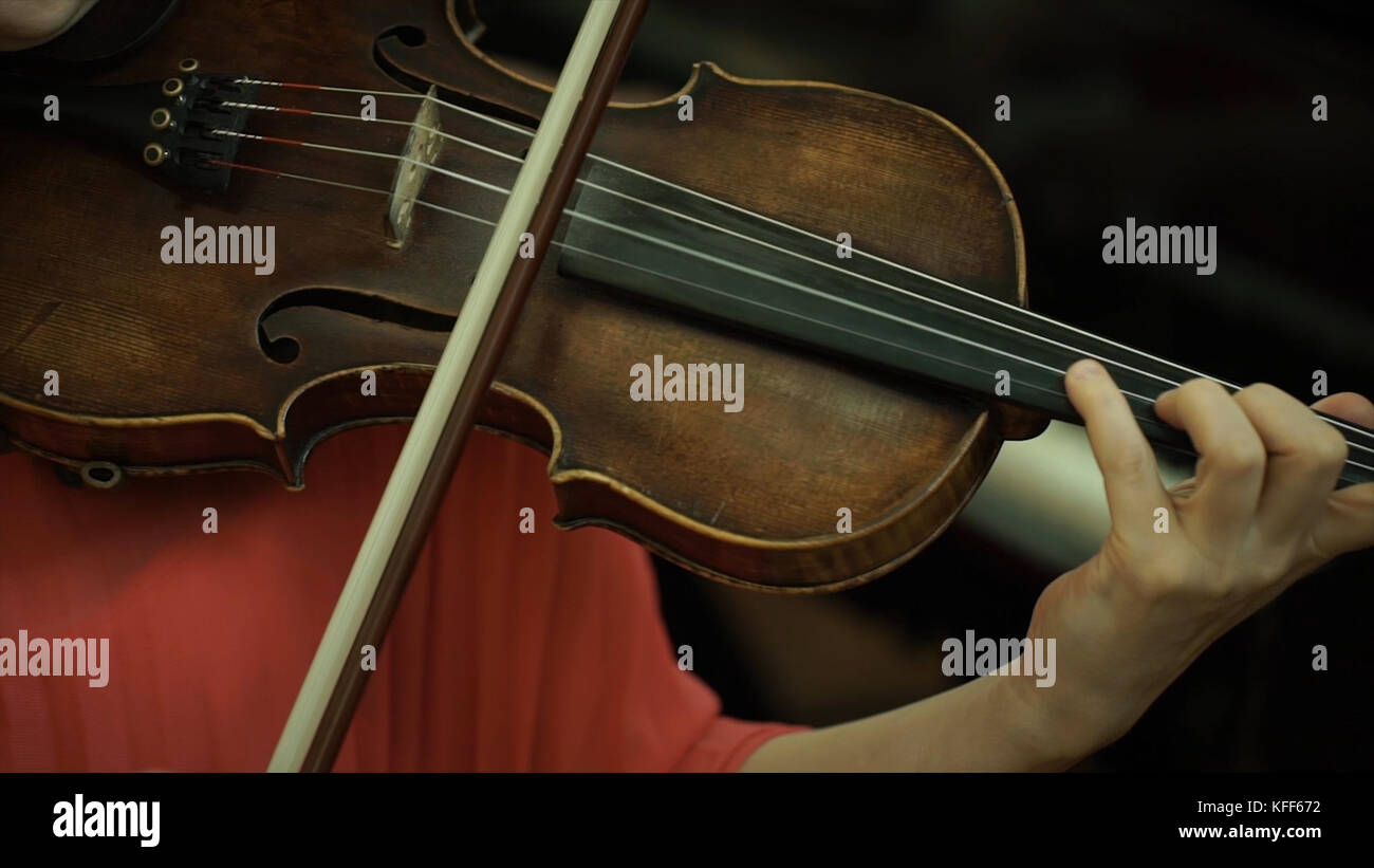 Girl's hand on the strings of a violin. Girl's hand on the fingerboard