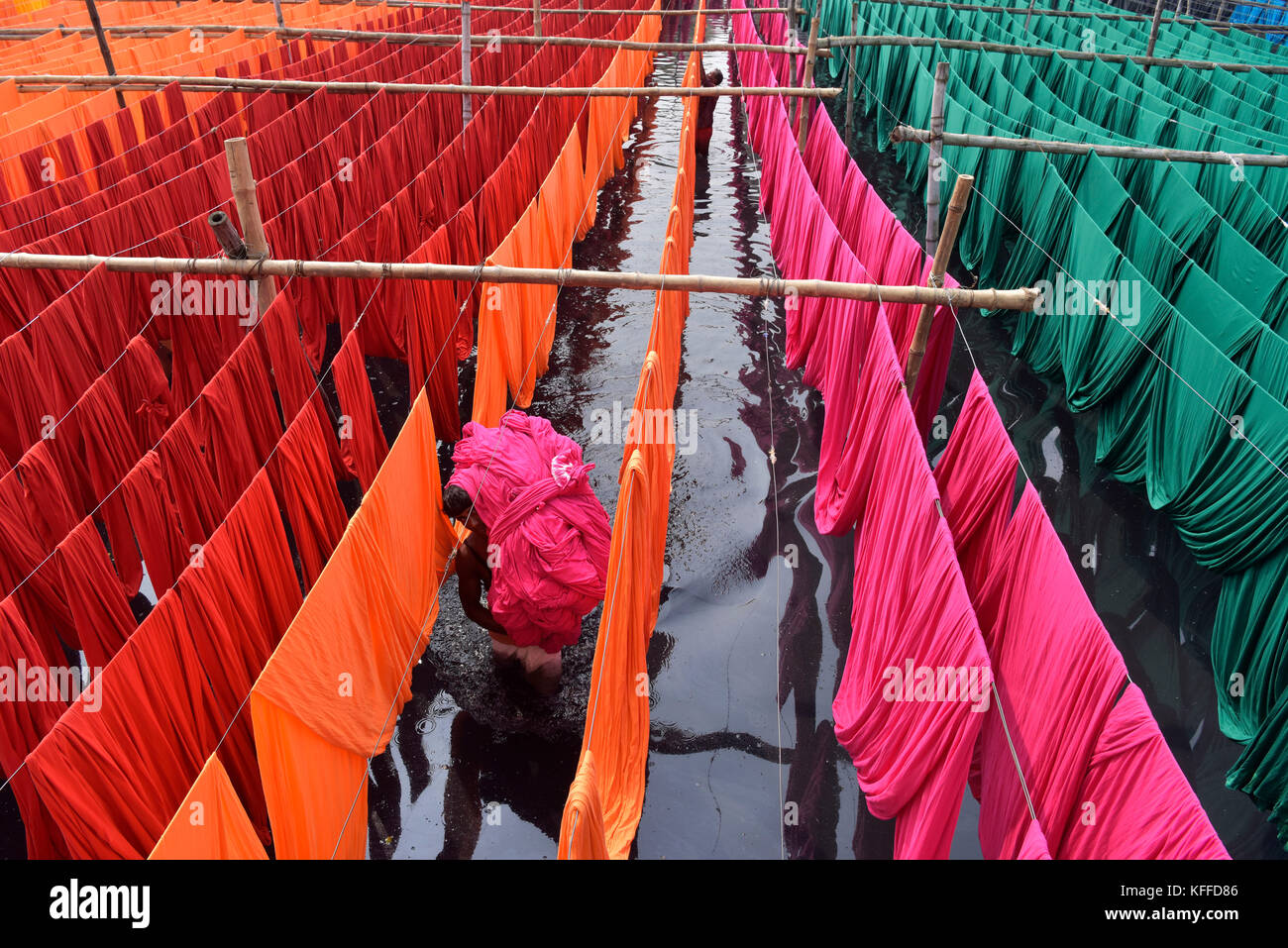 A Bangladeshi worker carries Garments fabric after dries them under the