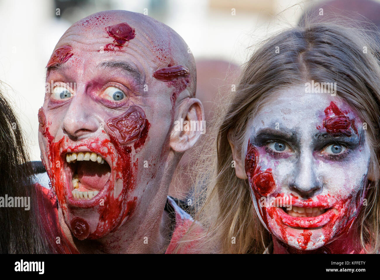 Bristol, UK. 28th Oct, 2017. A man and a woman dressed as zombies are pictured as they participate in a zombie walk through the city centre. Stock Photo