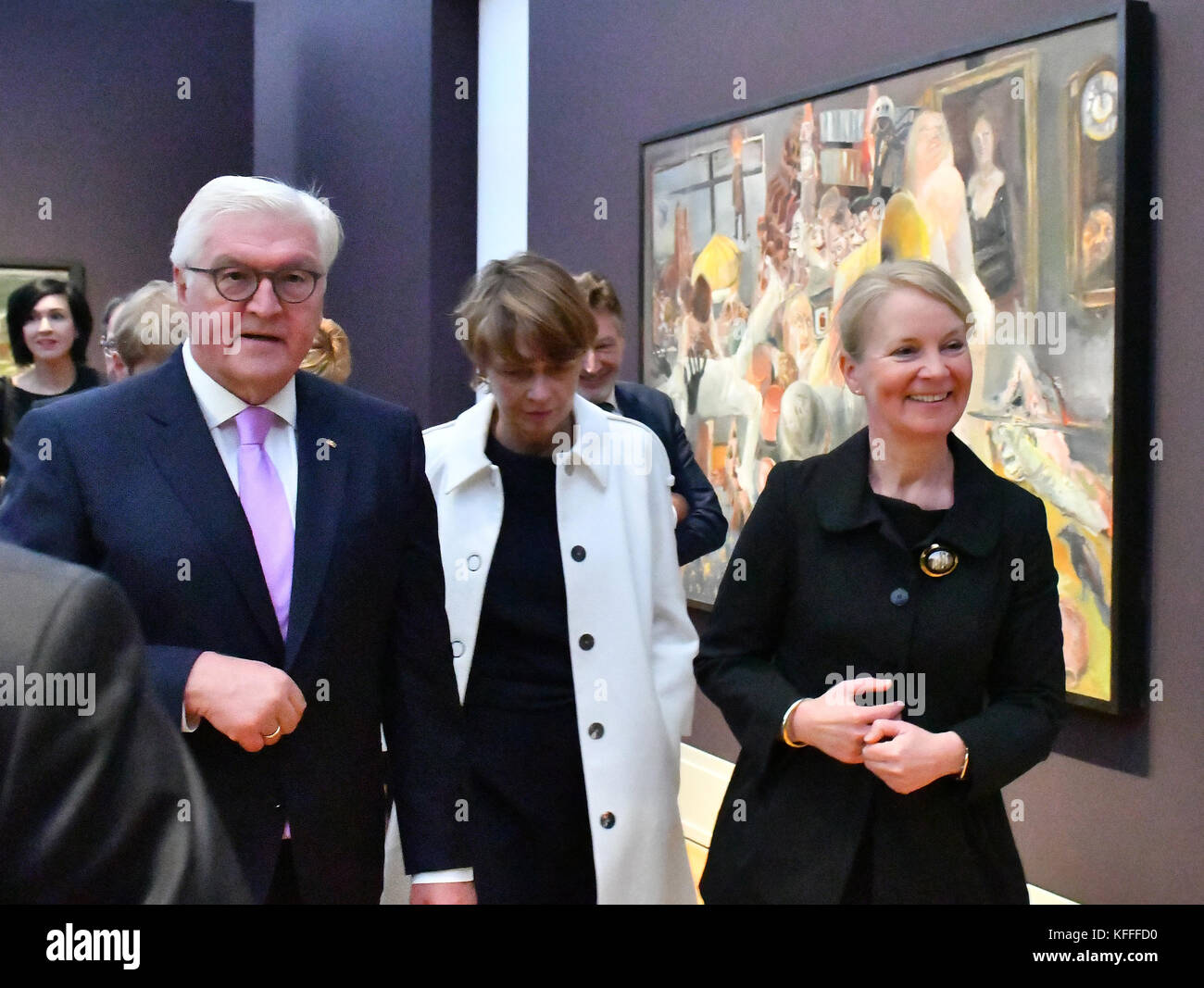 German president Frank Walter Steinmeier, his wife Elke Büdenbender (C) and museum direcotr Ortrud Westheider walk past a painting by Bernhard Heisig displayed at the 'Behind the Mask: Artists in the GDR' exhibition in Potsdam, Germany, 26 October 2017. The exhibition takes a look at the self-portrayal of artists in the GDR. Photo: Bernd Settnik/dpa Stock Photo