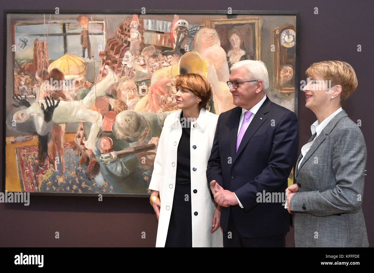 German president Frank Walter Steinmeier, his wife Elke Büdenbender (C) and museum direcotr Ortrud Westheider walk past a painting by Bernhard Heisig displayed at the 'Behind the Mask: Artists in the GDR' exhibition in Potsdam, Germany, 28 October 2017. The exhibition takes a look at the self-portrayal of artists in the GDR. Photo: Bernd Settnik/dpa Stock Photo