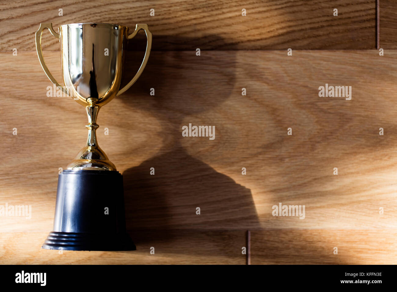 Gold winners trophy award on a wooden background Stock Photo