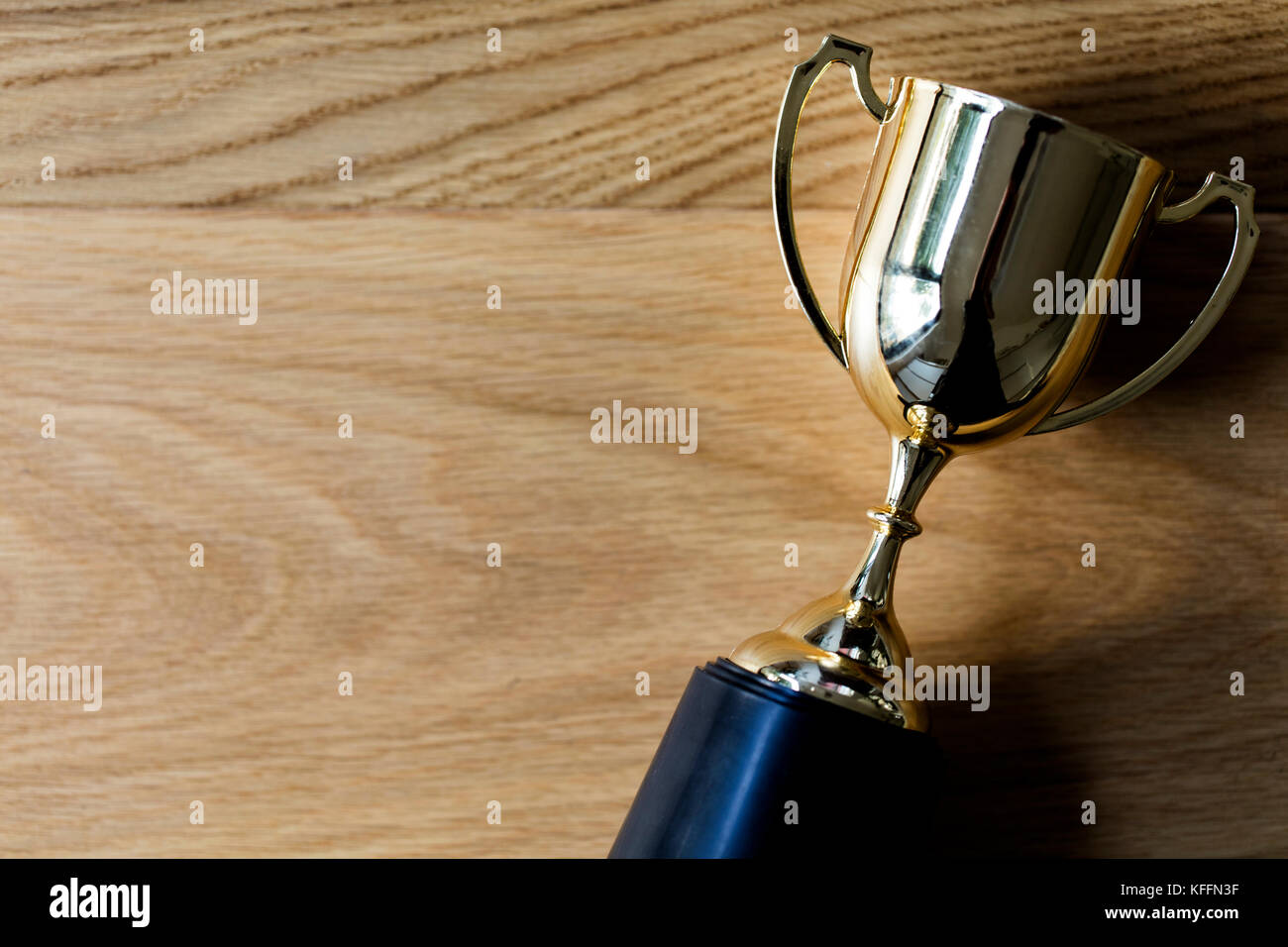 Gold winners trophy award on a wooden background Stock Photo