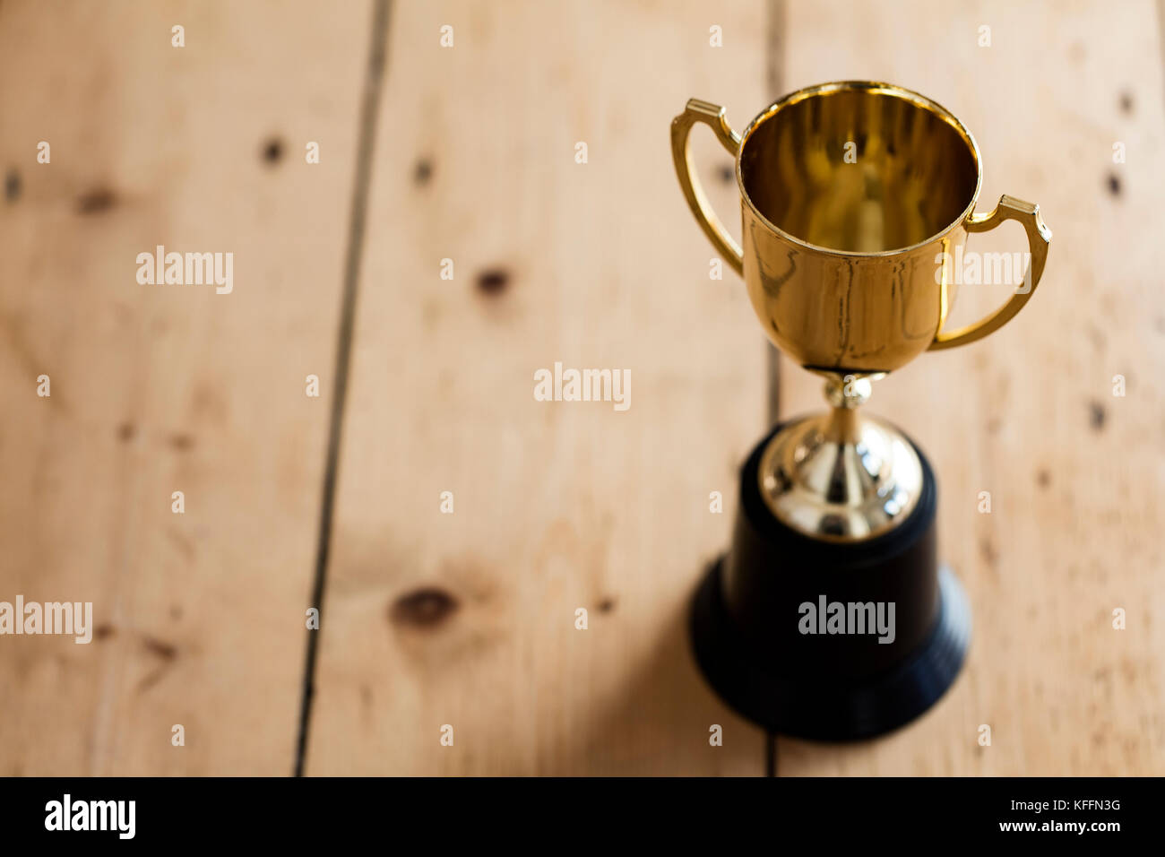 Gold winners trophy award on a wooden background Stock Photo