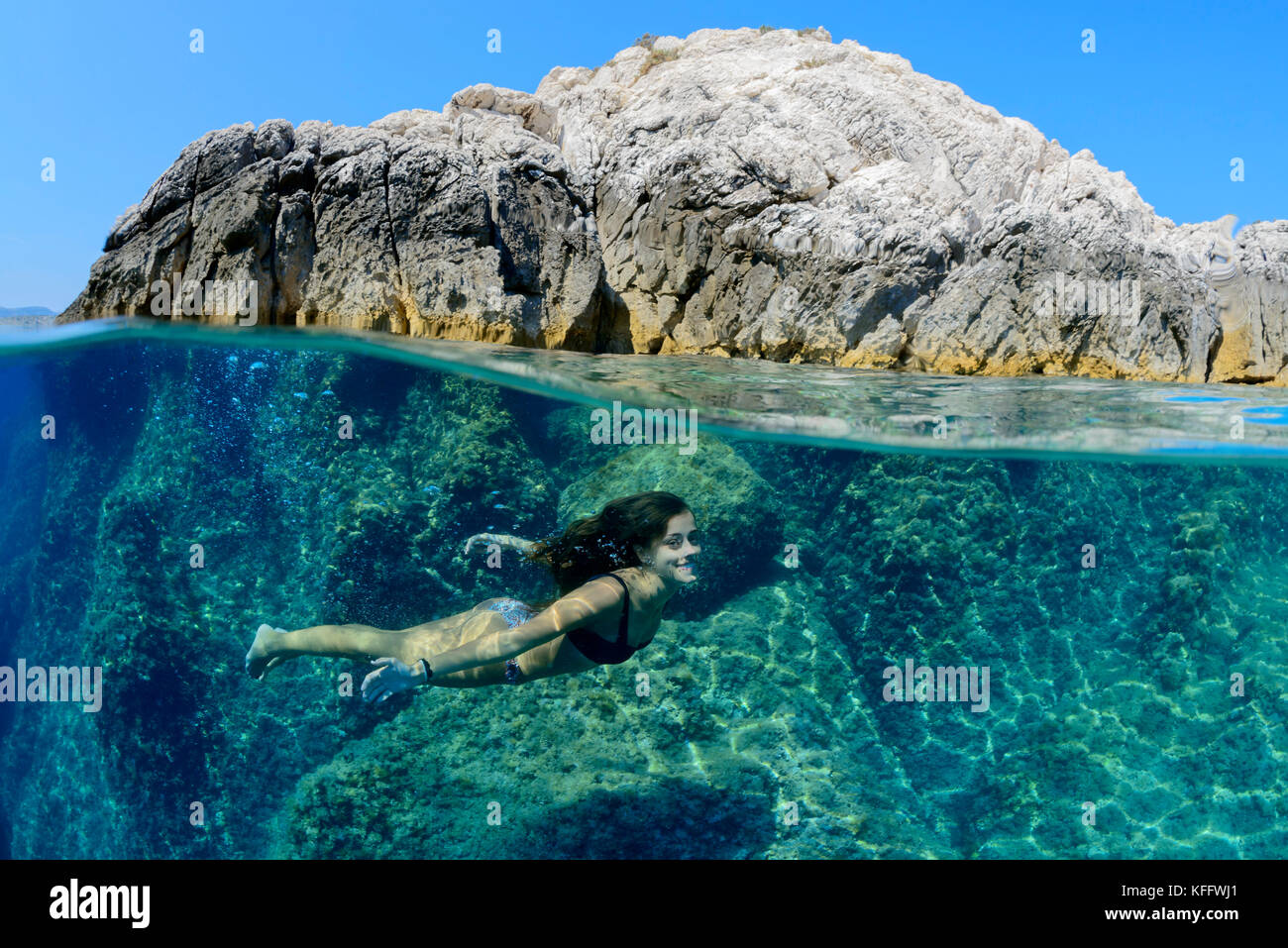 Splitlevel Picture, Girl swimming or diving underwaterin the sea, Adriatic Sea, Mediterranean Sea, Dalmatia, Croatia, MR Yes Stock Photo