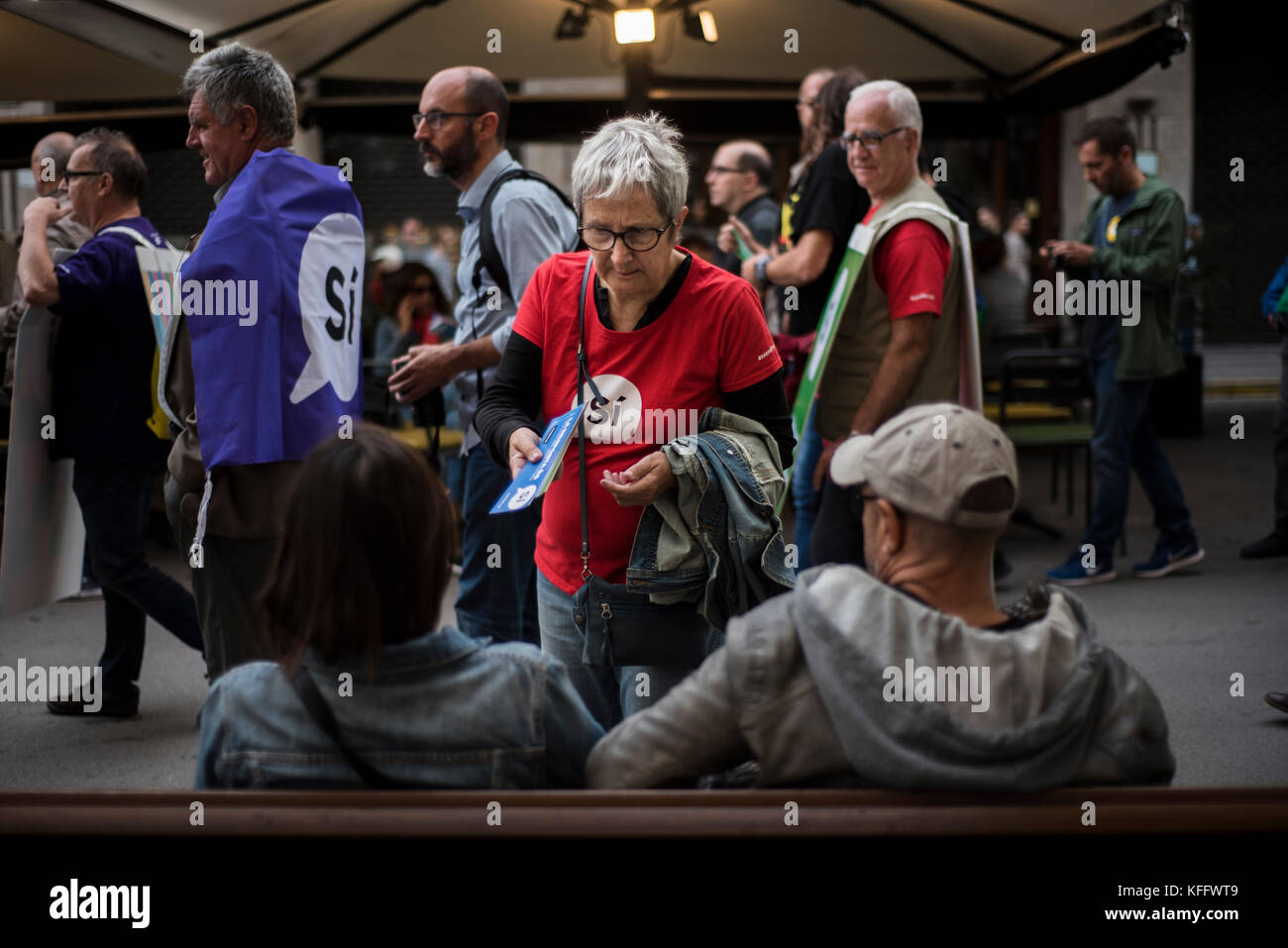 A member of the Catalan National Assembly (ANC) talks with a couple who does no support the referendum. Credit: Alamy / Carles Desfilis Stock Photo