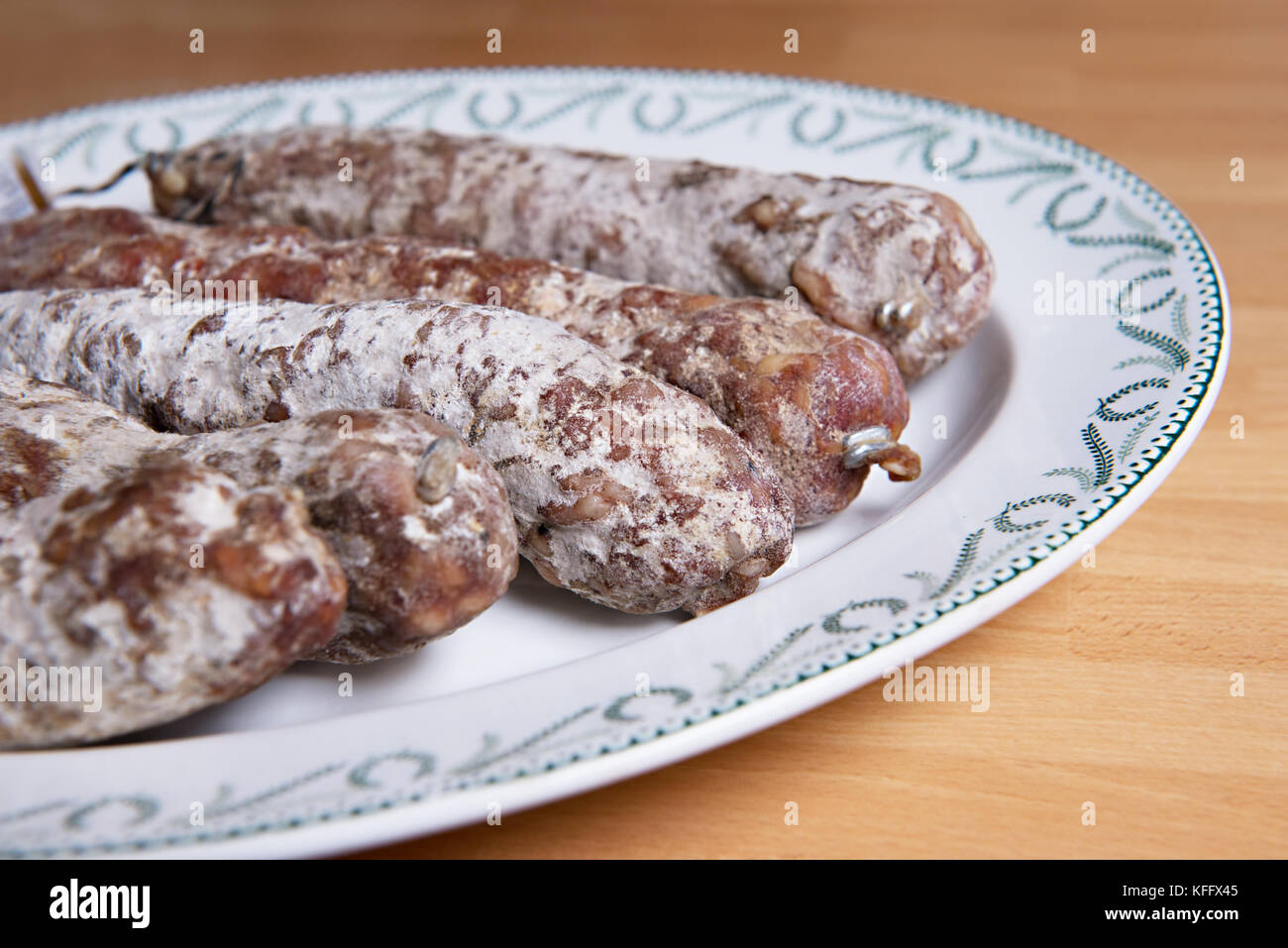 Traditional French artisan sausages on a vintage plate Stock Photo