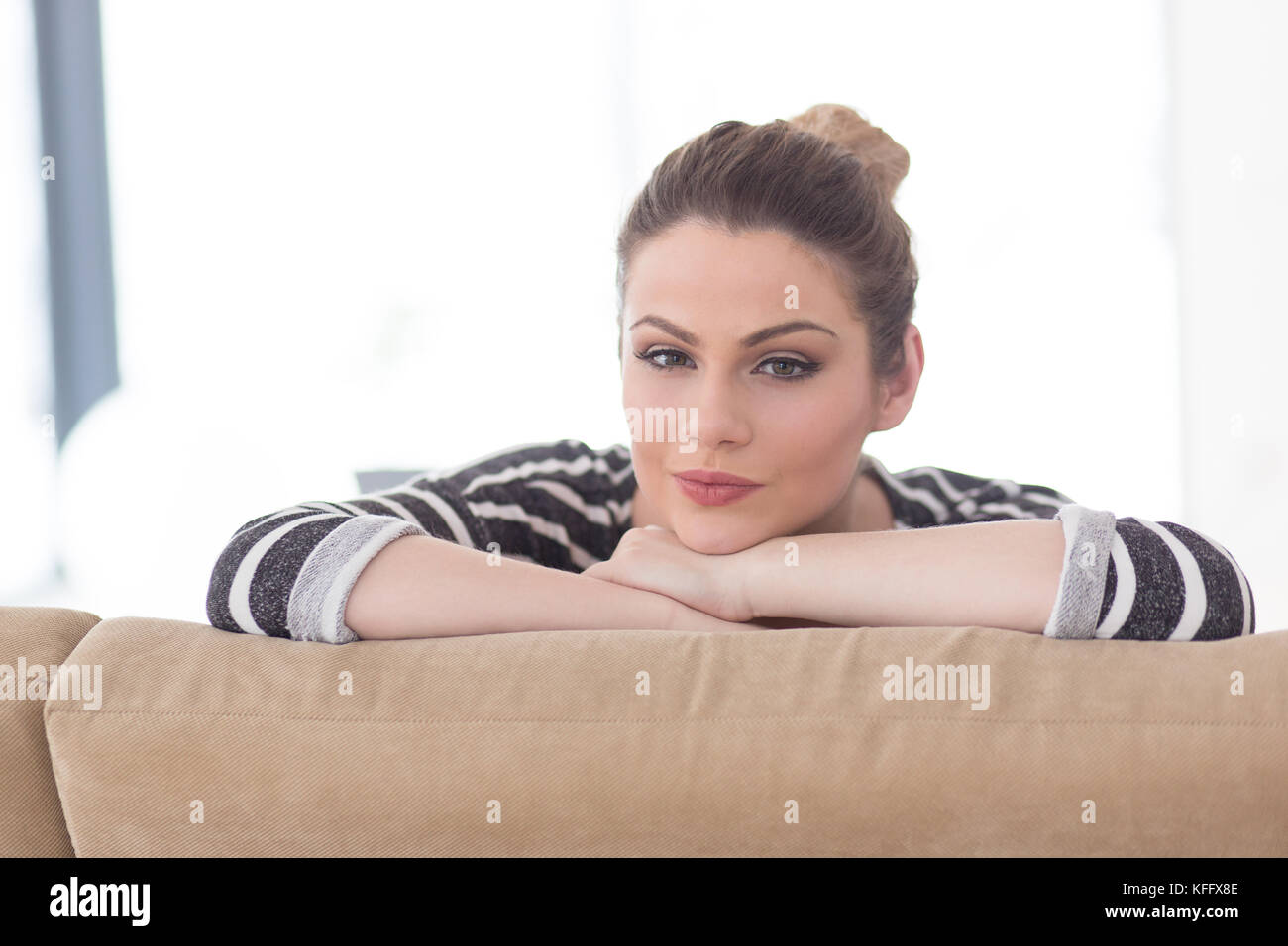 portrait of a young beautiful woman sitting on the sofa at home Stock ...