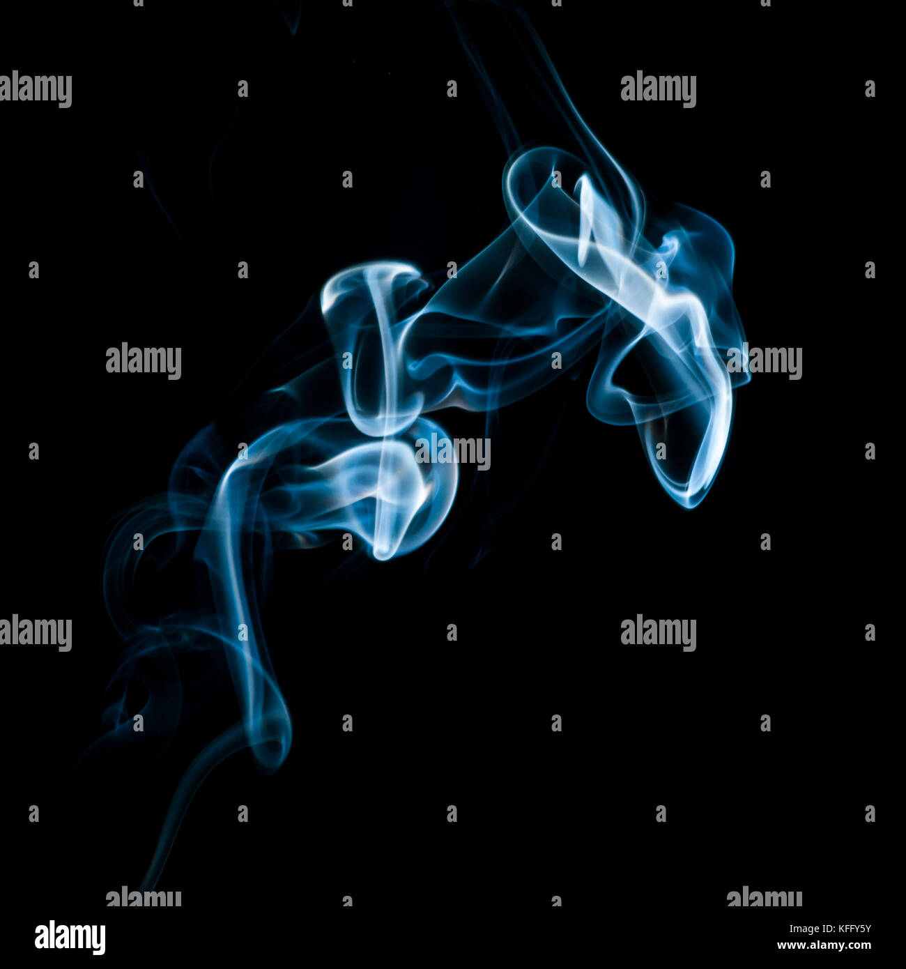 The abstract pattern made from smoke rising from an incense stick. Stock Photo