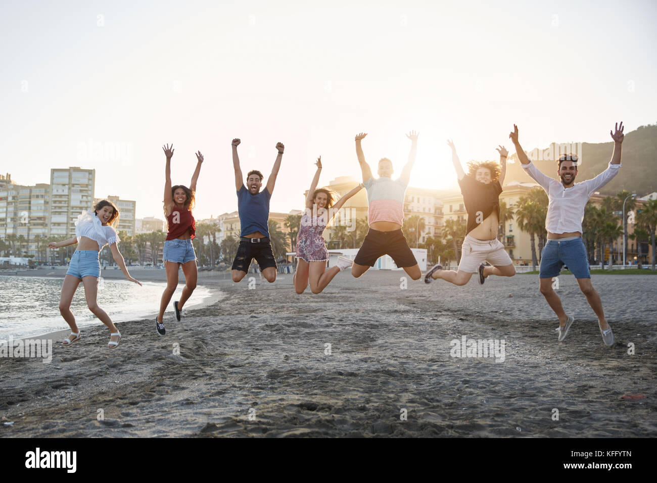 Portrait of group of happy friends jumping on beach Stock Photo